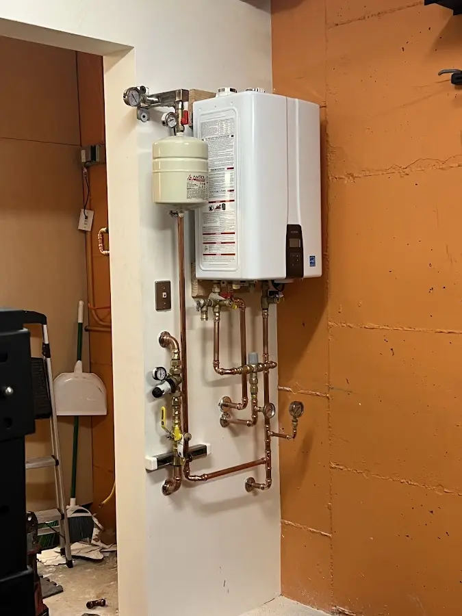 Plumbing technician inspecting water heater connections in Southbridge Town
